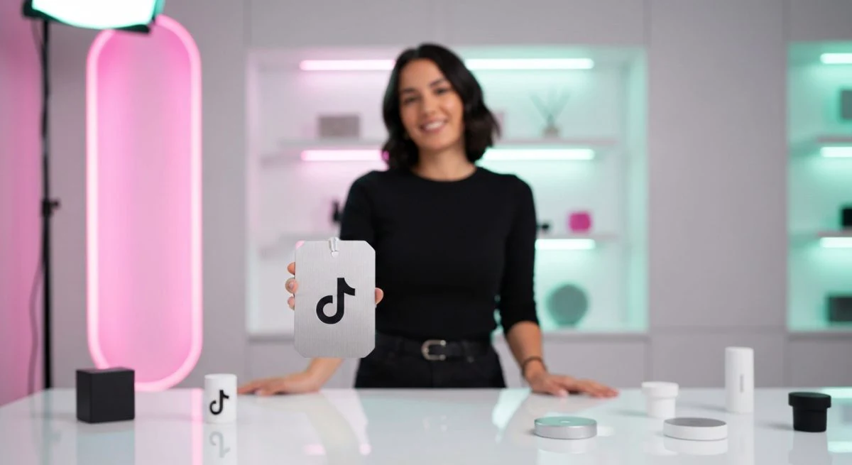 Creador de TikTok frente a mesa exhibidora con logo grabado