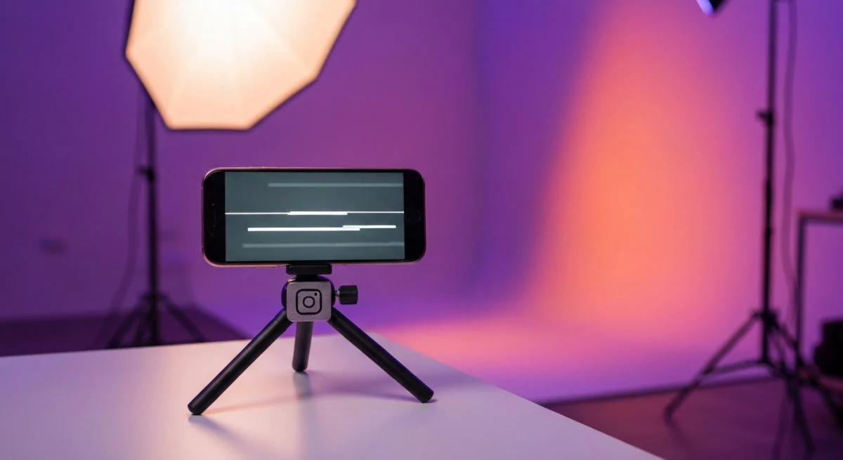 Smartphone sobre trípode pequeño en mesa de estudio con Instagram