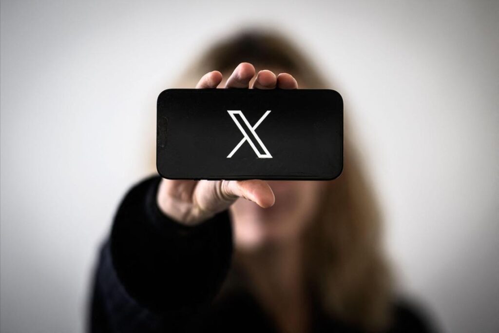 mujer sosteniendo movil con X en la pantalla