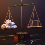 Balanza de latón de Instagram con cubo de cristal inclinando el equilibrio