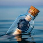 Botella de vidrio flotante con sello azul de Facebook y un mensaje dentro