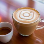 Café con leche latte art logo Instagram junto a espresso