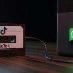 Casete de audio con logos de TikTok y WhatsApp iluminados