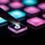 Dedo cerca de botones luminosos con logo de TikTok