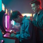 Jóvenes jugando en máquina recreativa clásica con iluminación neón