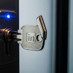 Llave moderna de metal pulido insertándose en cerradura oficina