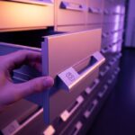 Mano abriendo cajón metálico minimalista en sala de archivos con logo de instagram