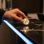 Mano colocando ficha metálica LinkedIn en mostrador corporativo elegante