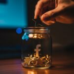 Mano depositando estrella dorada en frasco de vidrio transparente