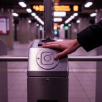 Mano presionando torniquete bloqueado en estación de metro vacía con logo de instagram