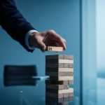 Mano profesional sacando bloque de Jenga con logo de LinkedIn en oficina moderna