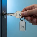 Mano sosteniendo llave moderna con logo de LinkedIn para puerta oficinas