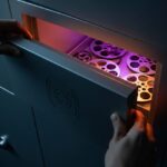 Manos abriendo caja fuerte con logo de Instagram con bobinas de película iluminadas
