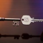 Manos intercambiando llaves metálicas Instagram logo fondo madera oscura
