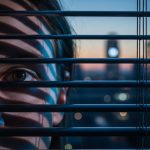 Ojo humano mirando entre persianas con luz azul de LinkedIn