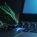 Dragón verde esmeralda realista sobre teclado de laptop con logo Facebook