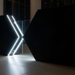Entrada futurista minimalista en forma de X con vidrio luminoso