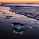Huella en la arena con logo de TikTok y olas