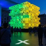 Instalación de Wordle con cubos brillantes en plaza moderna