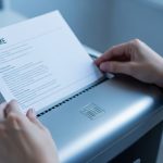 Manos alimentando un currículum en una trituradora LinkedIn moderna