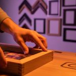Manos colocando una fotografía en un marco de madera artesanal