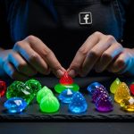 Manos con delantal oscuro organizando caramelos en forma de joyas