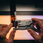 Manos de editor de cine usando herramienta vintage para splicing con logo de instagram