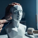Manos de escultor usando un cincel en un busto de mármol