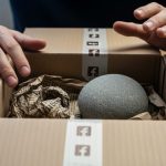 Manos decepcionadas sobre caja de envío con logo de Facebook