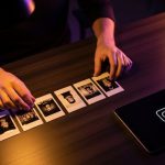Manos organizando fotos de película instantánea en escritorio oscuro