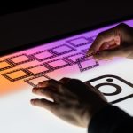 Manos organizando transparencias brillantes sobre mesa iluminada minimalista