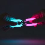 Manos uniendo un eslabón de cadena luminosa con pulsera TikTok