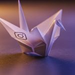 Pájaro de origami blanco con logo de Instagram en la ala