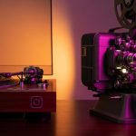 Proyector de cine y tocadiscos sobre mesa de madera oscura