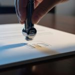 Mano presionando un embosser con logo de LinkedIn en papel