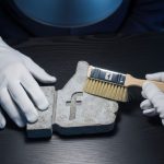 Manos con guantes blancos limpiando un ícono de Facebook Like