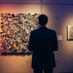 Persona observando arte abstracto en galería con logo de Instagram